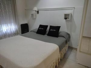 1 dormitorio con 2 camas con almohadas negras en Apart Zeta en Belén de Escobar