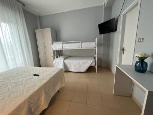 een kleine slaapkamer met een bed en een tv. bij Hotel Le Ali in Rimini