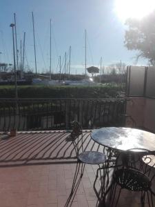 a table and chairs on a patio with a marina at A Santy's House 1piano no lift no shuttle solo parcheggio in strada 5 minuti da fermata bus per da fiera di roma nessun pasto no meal, air condiz ed extra bed FOR A FEE A PAGAMENTO in Fiumicino