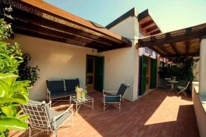 un patio con sillas, una mesa y un edificio en Apulia Victor Country Hotel en Alberobello