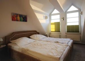 uma cama num quarto com duas janelas em Haus Elbe 1 Haus Elbe 1 - Wohnung 38 em Cuxhaven