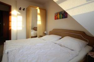 uma cama branca num quarto com em Haus Elbe 1 Haus Elbe 1 - Wohnung 38 em Cuxhaven