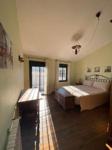 a bedroom with a large bed and a desk at Espaciosa y Elegante Casa Rural en Los Marines in Los Marines