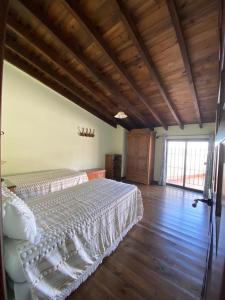 a bedroom with a bed and a wooden floor at Espaciosa y Elegante Casa Rural en Los Marines in Los Marines