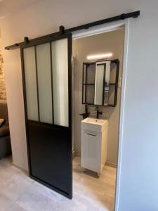 塞特港的住宿－Studio industriel proche gare，浴室设有黑色的门和水槽。