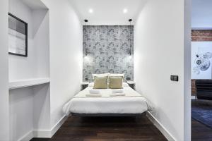 1 dormitorio con 1 cama en una habitación blanca en Serrano Style, by Presidence Rentals, en Madrid