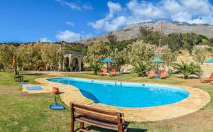 una piscina en un patio con un banco de madera en Petra-Mare 2, en Triopetra