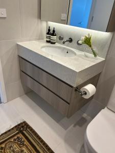 a bathroom with a sink and a toilet at New & Modern Loft 1bd w/Pool&Gym in Canberra