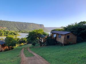 a small house on a hill next to a road at Entendeni Lodge SelfCatering in Inanda