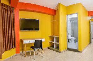 um quarto com uma televisão, uma secretária e um WC em Hotel Royal em Ica