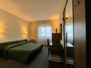 ビナスコにあるHotel La Golettaのベッドとデスクが備わるホテルルームです。