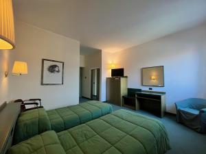 a hotel room with two beds and a television at Hotel La Goletta in Binasco