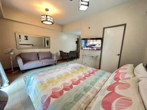 a bedroom with a large bed and a couch at Palm Tree Two Villas in Manila