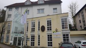 a large white building with cars parked in front of it at Weinhotel Römerbad in Bad Salzuflen