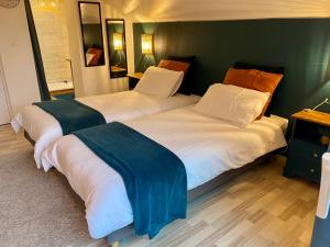 two beds sitting next to each other in a bedroom at la chambre d hotes de marie indépendante et sa terrasse avec vue panoramique proche alpes mancelles in Sillé-le-Guillaume