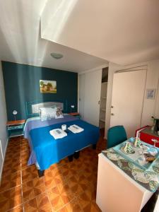 Un dormitorio con una cama azul y una mesa. en Anyrcoy, en Viña del Mar