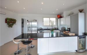 a kitchen with white cabinets and a black counter top at Awesome Home In La Gaude With Kitchen in La Gaude