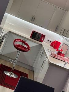 a red stool in a white kitchen with a sink at Modern 2bedrooms in woolwich in Woolwich