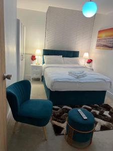 sypialnia z łóżkiem oraz niebieskim krzesłem i krzesłem w obiekcie Modern 2bedrooms in woolwich w mieście Woolwich