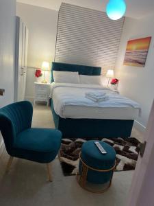a bedroom with a bed and a chair and a stool at Modern 2bedrooms in woolwich in Woolwich