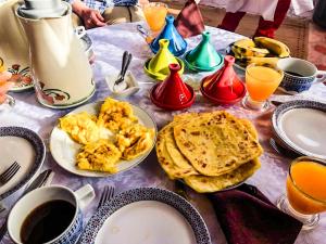 stół z talerzami jedzenia i napojów w obiekcie Riad Kasbah Omar w mieście Ourika