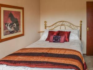 a bedroom with a bed with red pillows at Lakeland Bungalow in Oulton