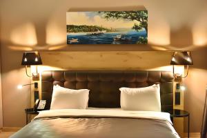 a bed with two pillows and a painting above it at Kerthill Hotel in Istanbul