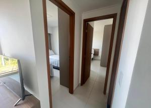 a hallway with a room with a bed and a mirror at Mana beach 2 quartos Muro Alto Ipojuca in Ipojuca