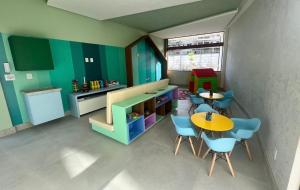 une petite chambre avec une table et des chaises ainsi qu'une cuisine dans l'établissement Mana beach 2 quartos Muro Alto Ipojuca, à Ipojuca