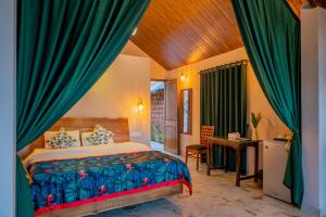um quarto com uma cama e uma secretária num quarto em Nirvana Hill Resort em Curtorim mais 37 fotografias