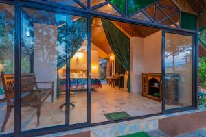 ein Wohnzimmer mit Glasfenstern und einem Kamin in der Unterkunft Nirvana Hill Resort in Curtorim