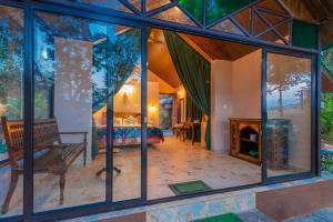 uma sala de estar com janelas de vidro e uma lareira em Nirvana Hill Resort em Curtorim