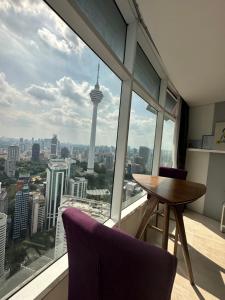 una mesa y sillas en una habitación con vistas al perfil urbano de Seattle en near klcc vortex suites by PLUS POIN, en Kuala Lumpur