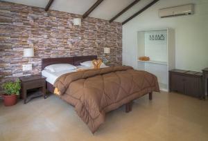 a bedroom with a large bed in a brick wall at Palolem Beach Resort in Palolem