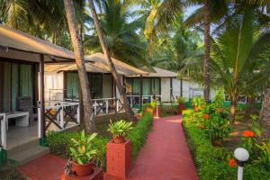 a resort with palm trees and a red path at Palolem Beach Resort in Palolem