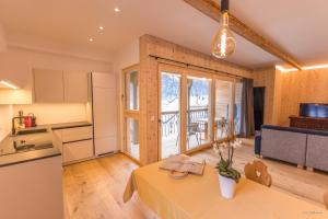 a kitchen and living room with a table in a room at Hotel Münsterhof in Müstair