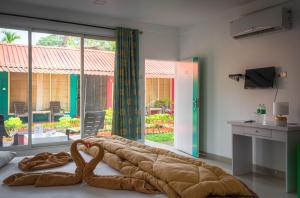 a bedroom with a large bed with a large window at Palolem Beach Resort in Palolem