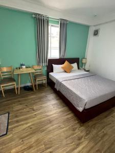 1 dormitorio con cama, escritorio y mesa en Nouveau Happy Inn - Bến Thành, en Ho Chi Minh