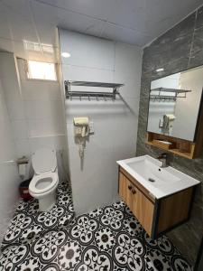a bathroom with a toilet and a sink and a mirror at Nouveau Happy Inn - Bến Thành in Ho Chi Minh City