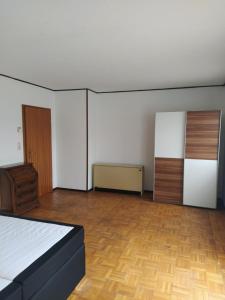 an empty room with a bed and a wooden floor at In Kadenbach, Schöne Ferienwohnung im ruhigen in Kadenbach