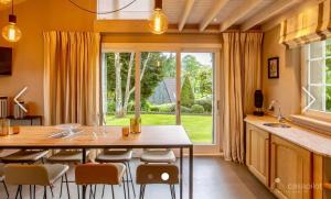 a kitchen with a table and chairs and a large window at Côté Mont in Malmedy