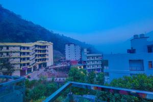 a view of a city with buildings and a mountain at Perfectstayz Value Forest Valley Near Waterfall in Rishīkesh