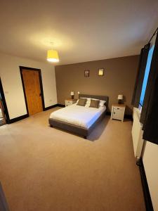 a large bedroom with a bed and a window at Stable Cottage in Ross on Wye