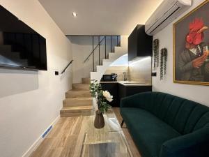 a living room with a green couch and a staircase at La Mini Casa in Córdoba