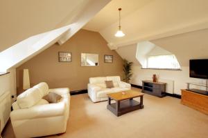 a living room with two couches and a tv at Stable Cottage in Ross on Wye