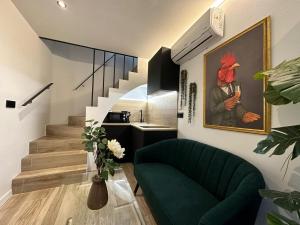 a living room with a green couch and a painting on the wall at La Mini Casa in Córdoba