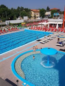 a large swimming pool with people in the water at Hotel Monti in Riccione