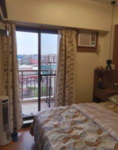 a bedroom with a bed and a large window at Joey's Place Calathea DMCI in Manila +14 photos