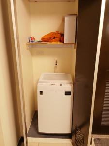 een kleine witte wasmachine en droger in een kleine kamer bij Joey' Condo Place in Manilla