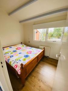 ein Schlafzimmer mit einem Bett in einem Zimmer mit einem Fenster in der Unterkunft Vakantiehuis Robbenoort 18 in Lauwersoog